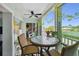Enclosed balcony featuring a ceiling fan, seating, and views of the surrounding community and water at 10216 Regal Dr # 310, Largo, FL 33774