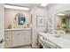 Bright bathroom with a vanity, decorative mirror, and floral accents at 10216 Regal Dr # 310, Largo, FL 33774
