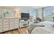 This is a bedroom featuring a TV, dresser, and a sliding glass door to a balcony with water views at 10216 Regal Dr # 310, Largo, FL 33774