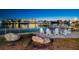 Outdoor seating area with white Adirondack chairs, lush landscaping, and peaceful views of the water at 10216 Regal Dr # 310, Largo, FL 33774
