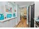 Galley kitchen with built in serving bar leading to dining area, stainless refrigerator, and wood flooring at 10216 Regal Dr # 310, Largo, FL 33774