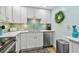 Bright kitchen featuring stainless steel appliances, white cabinetry, and a charming tile backsplash at 10216 Regal Dr # 310, Largo, FL 33774