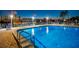 Community pool with inviting turquoise waters, poolside seating, and views of the city skyline across the canal at 10216 Regal Dr # 310, Largo, FL 33774