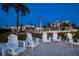 Inviting pool area featuring comfortable seating, umbrellas, palm trees, and charming Adirondack chairs at 10216 Regal Dr # 310, Largo, FL 33774