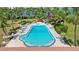 Community outdoor swimming pool surrounded by lush tropical landscaping and lounge seating at 10216 Regal Dr # 310, Largo, FL 33774