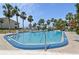 Community swimming pool with refreshing water, surrounding lounge chairs, and palm trees at 10216 Regal Dr # 310, Largo, FL 33774