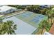Aerial view of tennis and basketball courts with palm trees and lush landscaping on a sunny day at 10216 Regal Dr # 310, Largo, FL 33774