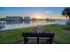 Scenic waterfront view featuring a tranquil bench, buildings, and a stunning sunset over the bay at 10216 Regal Dr # 310, Largo, FL 33774