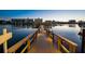 Stunning waterfront view at dusk featuring a charming lit dock reflecting over the calm waters at 10216 Regal Dr # 310, Largo, FL 33774