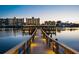 Stunning waterfront view at dusk featuring a charming lit dock reflecting over the calm waters at 10216 Regal Dr # 310, Largo, FL 33774