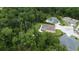 Aerial view of a home with a screened in pool in wooded area at 10305 Worthy Lamb Way, New Port Richey, FL 34654