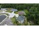 An aerial view displays homes on well-kept lots near a pond, complemented by mature landscaping and ample parking at 10305 Worthy Lamb Way, New Port Richey, FL 34654