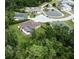 An aerial view features a property with a screened pool, nestled near a tranquil pond and lush greenery at 10305 Worthy Lamb Way, New Port Richey, FL 34654