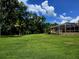 Expansive backyard features a large, well-maintained lawn and a screened-in pool area at 10305 Worthy Lamb Way, New Port Richey, FL 34654