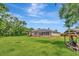 Expansive backyard with a screened in patio, mature trees and lush lawn at 10305 Worthy Lamb Way, New Port Richey, FL 34654