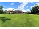 The extensive backyard boasts a lush lawn and a screened-in pool area perfect for entertaining at 10305 Worthy Lamb Way, New Port Richey, FL 34654