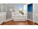 Spacious primary bathroom with a shower, soaking tub, dual sinks, and a large window at 10305 Worthy Lamb Way, New Port Richey, FL 34654