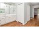 Bathroom with bright white cabinets, vanity, and a large mirror over the sink and hardwood floors at 10305 Worthy Lamb Way, New Port Richey, FL 34654