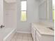 Bathroom with white vanity, neutral tile floors, bathtub, and a window providing natural light at 10305 Worthy Lamb Way, New Port Richey, FL 34654