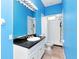 Bright bathroom featuring blue walls, granite counters, and shower with tub at 10305 Worthy Lamb Way, New Port Richey, FL 34654
