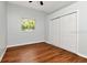 Bedroom with a window for natural light and a closet with sliding doors and hardwood floors at 10305 Worthy Lamb Way, New Port Richey, FL 34654