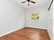 Bright bedroom featuring hardwood floors, ceiling fan, and natural light from a large window at 10305 Worthy Lamb Way, New Port Richey, FL 34654