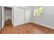 Bedroom featuring a closet with sliding doors, hardwood floors and a window with natural light at 10305 Worthy Lamb Way, New Port Richey, FL 34654
