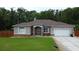 Charming single story home with a lush green lawn and an attached two car garage at 10305 Worthy Lamb Way, New Port Richey, FL 34654