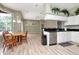 Open kitchen and dining area with stainless steel appliances and wood floors at 10305 Worthy Lamb Way, New Port Richey, FL 34654