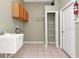 Functional laundry room with tiled flooring and storage cabinets at 10305 Worthy Lamb Way, New Port Richey, FL 34654