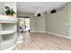 Sunlit living area featuring smooth wood flooring, a fireplace, and open access to the outdoor patio at 10305 Worthy Lamb Way, New Port Richey, FL 34654