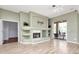 Spacious living room with wood floors, a fireplace, and sliding glass doors that let in natural light at 10305 Worthy Lamb Way, New Port Richey, FL 34654