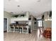Open-concept living space featuring a bar area and a dining area with lots of natural light at 10305 Worthy Lamb Way, New Port Richey, FL 34654