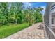 Brick patio with relaxing seating overlooks lush, green yard at 10305 Worthy Lamb Way, New Port Richey, FL 34654