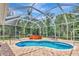 Backyard pool with hot tub enclosed in a screened lanai at 10305 Worthy Lamb Way, New Port Richey, FL 34654