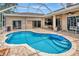 A kidney-shaped pool and a covered patio for outdoor enjoyment at 10305 Worthy Lamb Way, New Port Richey, FL 34654