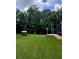Large yard with a wood shed and ample space, surrounded by mature trees for privacy at 10305 Worthy Lamb Way, New Port Richey, FL 34654