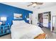 Cozy bedroom with blue accent wall, ceiling fan, and closet; featuring a bright blue cabinet at 11376 119Th Ter, Largo, FL 33778