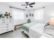 Bright bedroom featuring a white dresser, bench, ceiling fan, and large windows with sheer curtains at 11376 119Th Ter, Largo, FL 33778