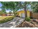 Exterior view showing a charming home with a driveway leading to the garage, a well-kept lawn, and mature trees at 11376 119Th Ter, Largo, FL 33778