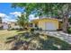 Charming yellow single-story home featuring an attached one car garage and mature landscaping at 11376 119Th Ter, Largo, FL 33778