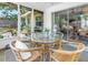 Comfortable screened-in porch with wicker furniture and glass table, perfect for relaxing and enjoying the outdoors at 11376 119Th Ter, Largo, FL 33778
