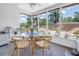 Inviting screened-in porch with wicker seating, glass table, and view of the well-maintained backyard at 11376 119Th Ter, Largo, FL 33778