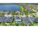 Aerial view of homes with screened pools, lush landscaping, and solar panels along a lake at 11742 Lake Lucaya Dr, Riverview, FL 33579
