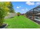 Large backyard with lush lawn, perfect for recreation and relaxation, and a screened pool enclosure at 11742 Lake Lucaya Dr, Riverview, FL 33579