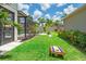 Landscaped backyard with pool access, cornhole game, trampoline, and lush grass at 11742 Lake Lucaya Dr, Riverview, FL 33579