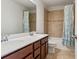 Bathroom with double sink vanity, tiled walls, and a shower with a blue curtain at 11742 Lake Lucaya Dr, Riverview, FL 33579