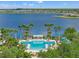 A community pool with lounge chairs, umbrellas, and lush landscaping, all with a lake view at 11742 Lake Lucaya Dr, Riverview, FL 33579