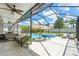 Covered and screened-in lanai area with a pool, spa, outdoor seating, and stylish patio furniture at 11742 Lake Lucaya Dr, Riverview, FL 33579