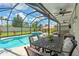 Outdoor dining area overlooks a screened-in pool and spa, with manicured landscaping and shaded seating at 11742 Lake Lucaya Dr, Riverview, FL 33579